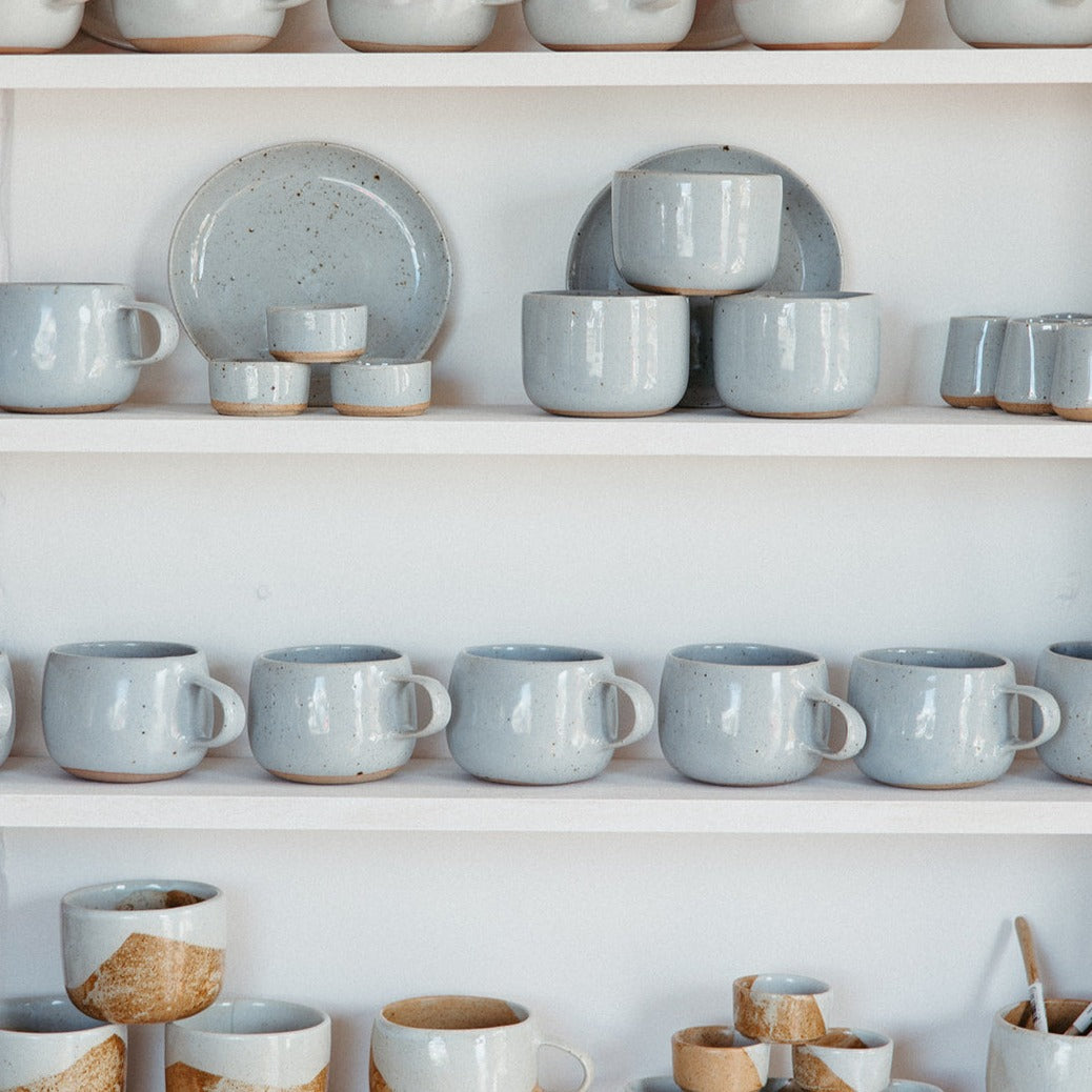 Stacked shelf with handmade ceramic mugs by Palinopsia Ceramics for tea and coffee