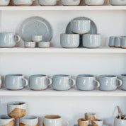 Stacked shelf with handmade ceramic mugs by Palinopsia Ceramics for tea and coffee