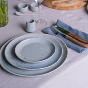 Handmade dinner plate with organic shape and blue grey speckle glaze colour 