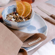 Breakfast bowl with cereal and fruit with caramel table linen napkin by Palinopsia Ceramics 